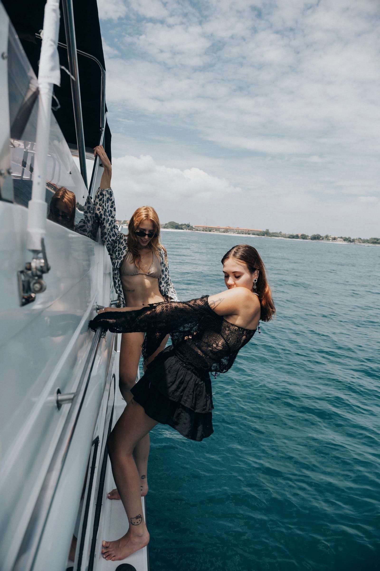 Two guests standing on the side deck of Freedom Yacht at sea