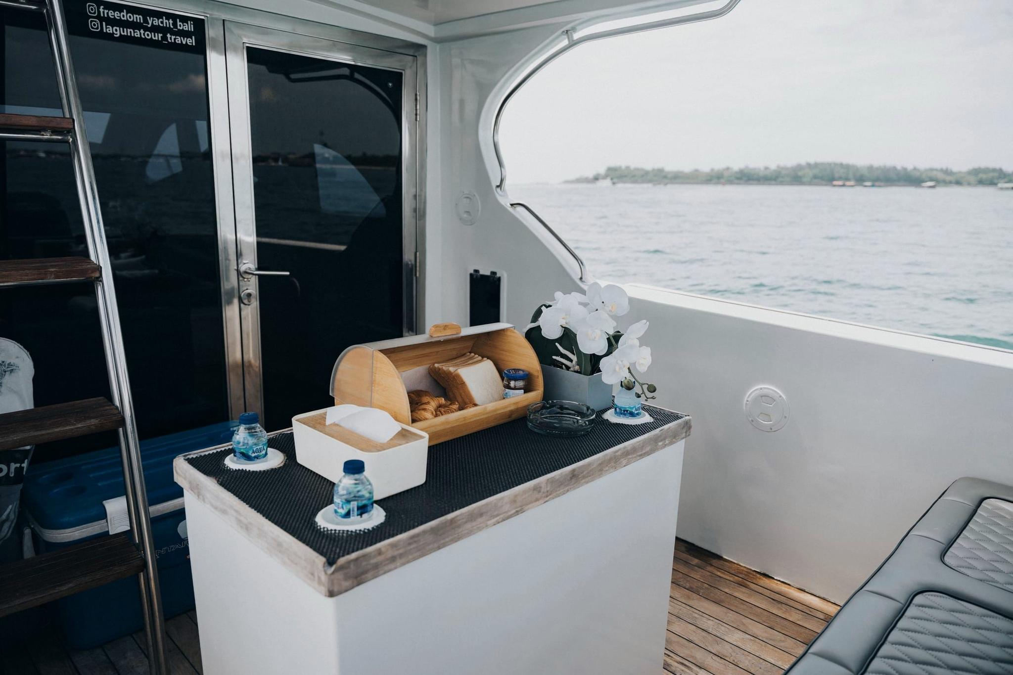 Crew member welcoming guests aboard a private yacht at Serangan Harbour